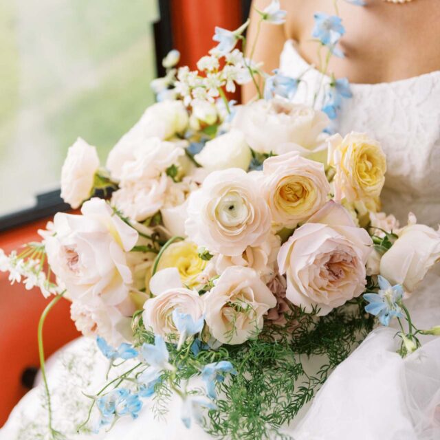 sitting bride holding bouquet of pink roses