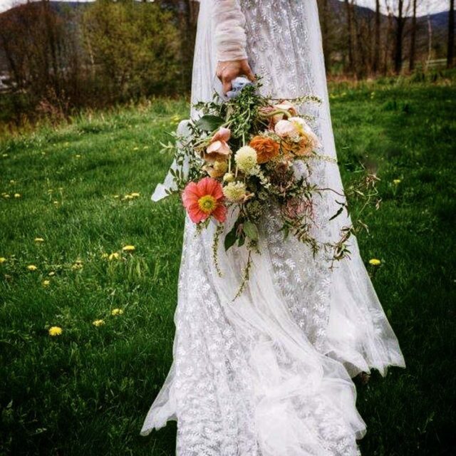 bride's arm holding bouquet of flowers