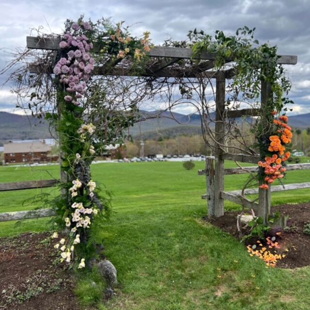 wedding arc decorated with orange, white, purple flowers