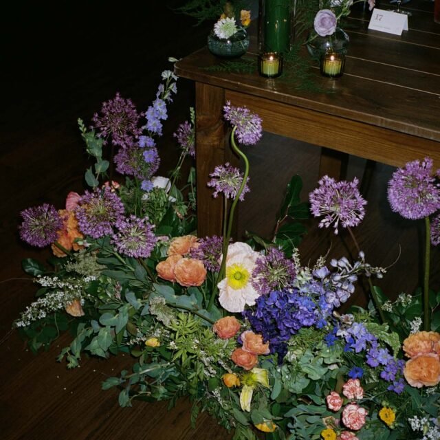 floral arrangement next to a piano with green candles