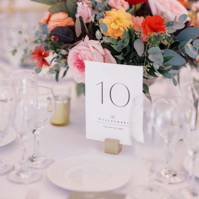table card with a floral arrangement behind it