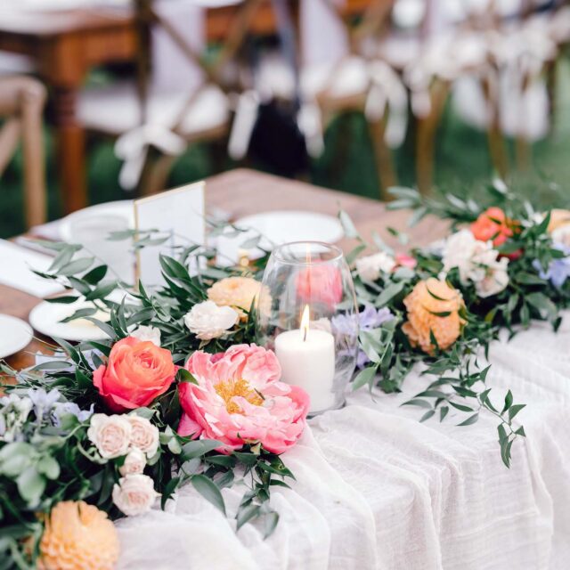 floral centerpiece with candle in the middle on a wedding table