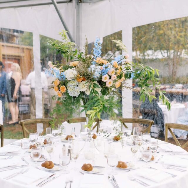 wedding table under a tent with floral centerpiece