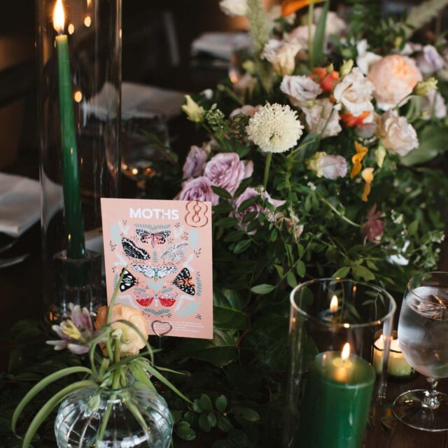 floral centerpiece with dark green candles on the table